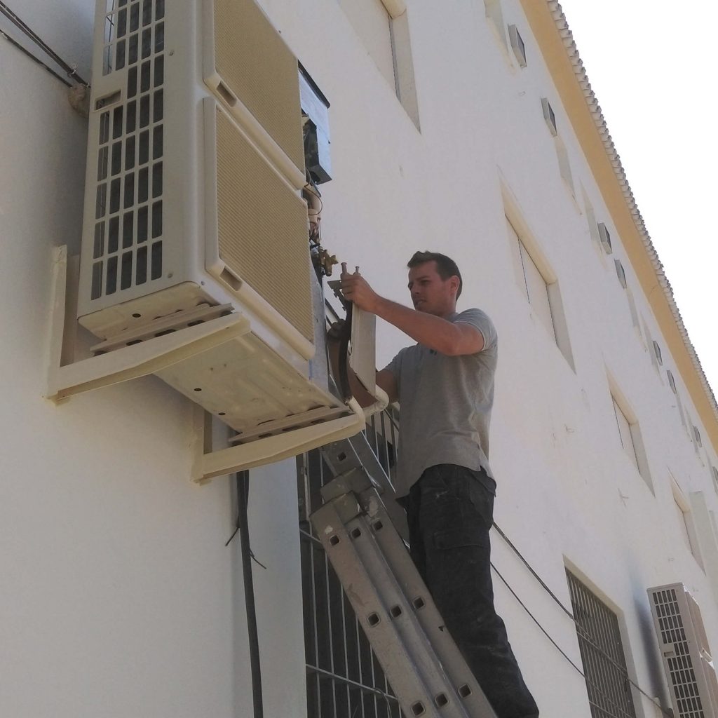 operario instalando un aire acondicionado en Salesianos de Antequera