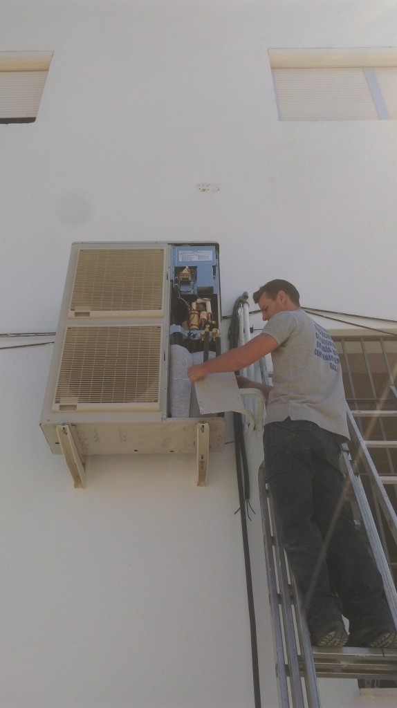 operario de Instalaciones Pulido Barba instalando un aire acondicionado